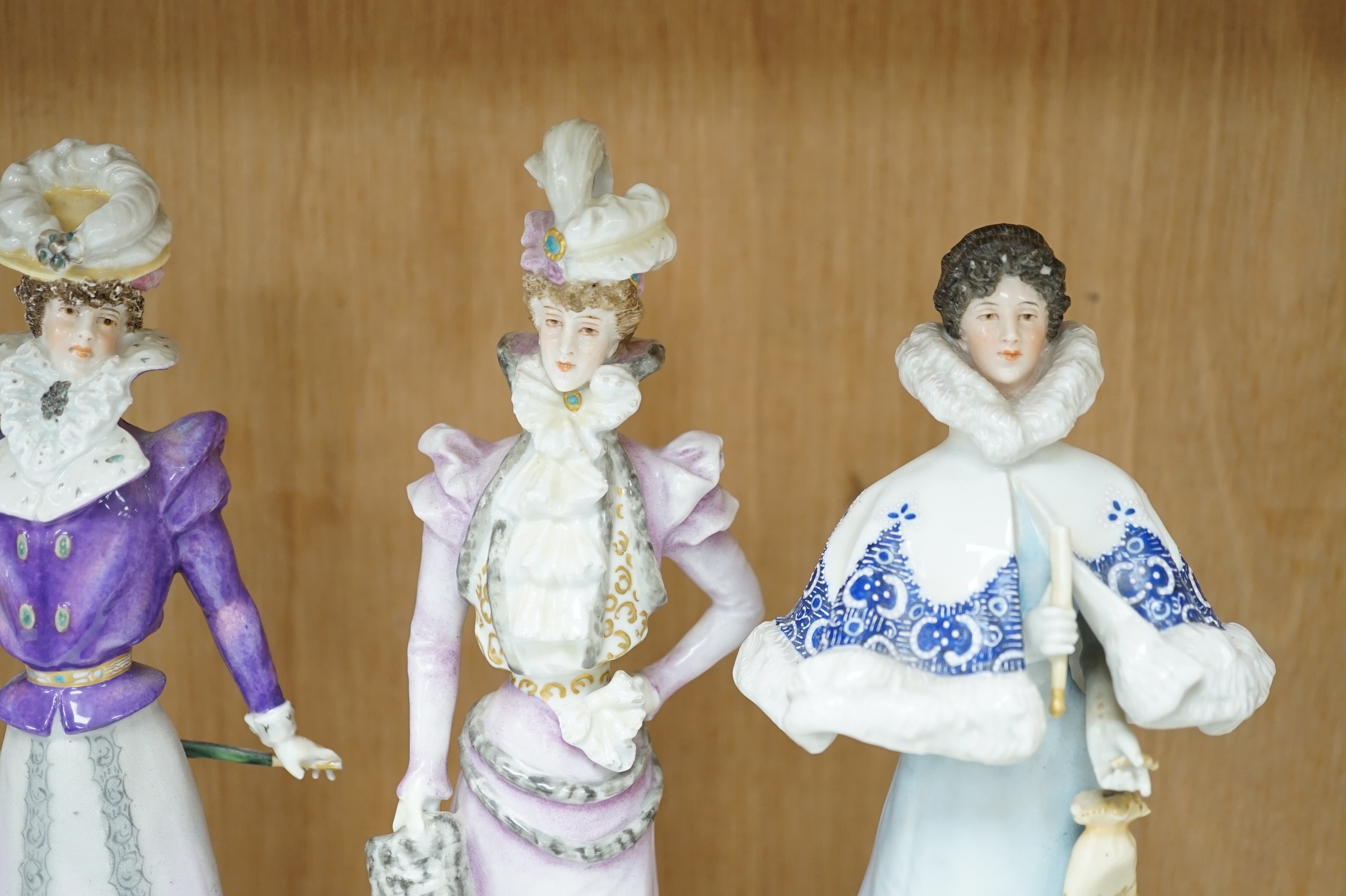 Four German Plaue porcelain figures of Edwardian fashionable ladies, tallest 27.5cm high. Condition - poor some chips